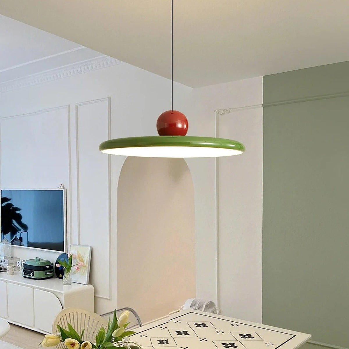 Green and red Juno saucer LED pendant light above a living and dining area