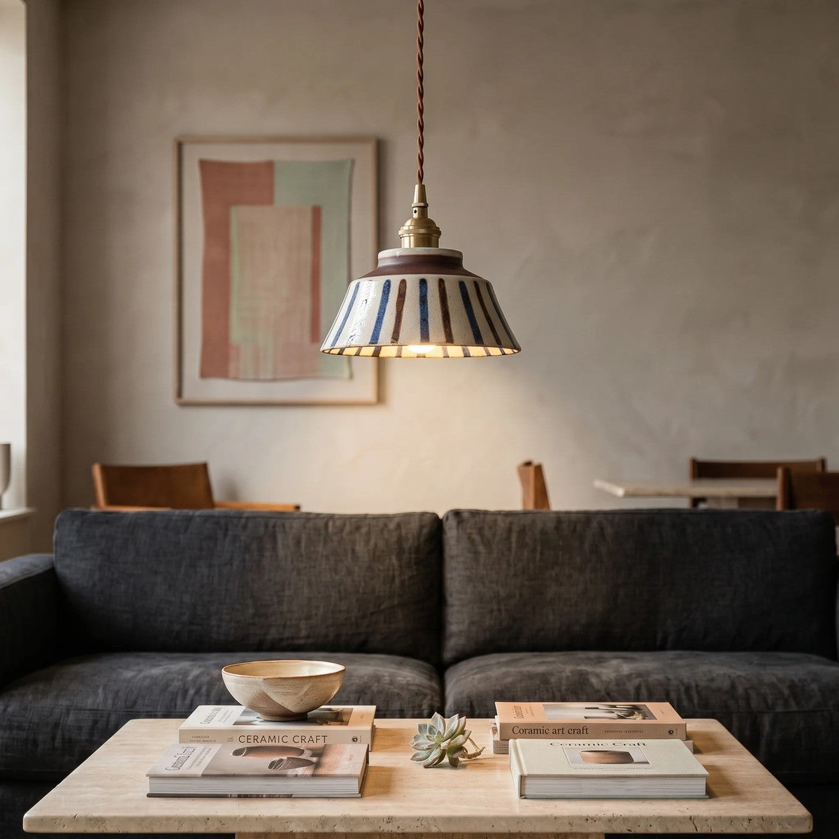 Hana ceramic pendant light in blue and brown stripe above a sofa in a living room