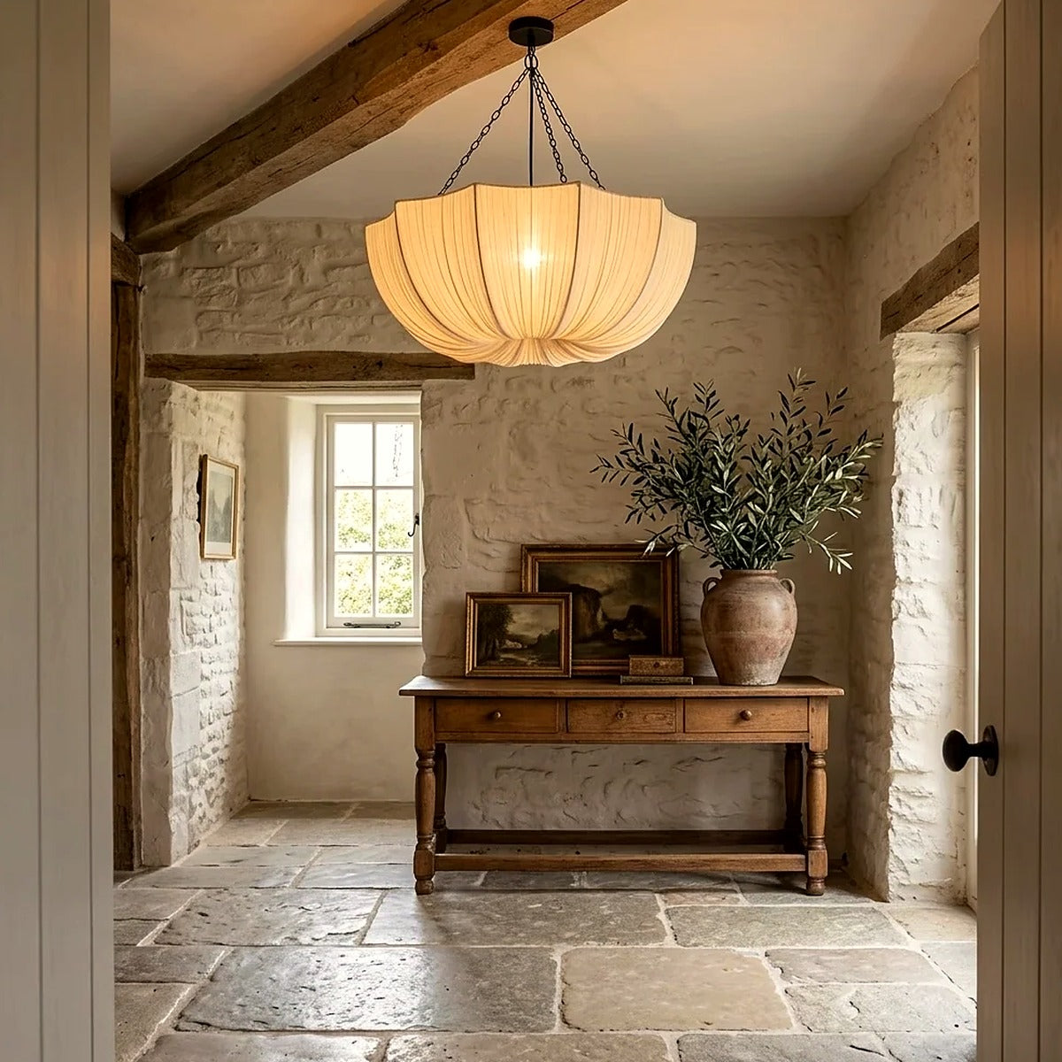 Maris pleated fabric chandelier lit in a stone entry hall