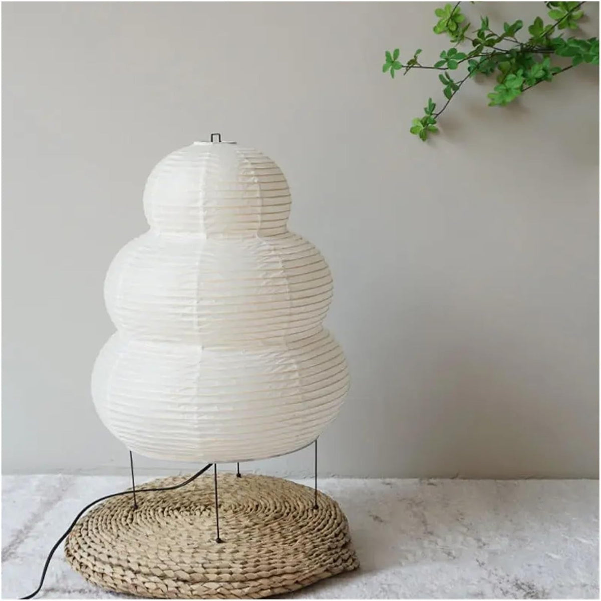 White Kumo three-tier paper lantern lamp on slender metal legs, switched off