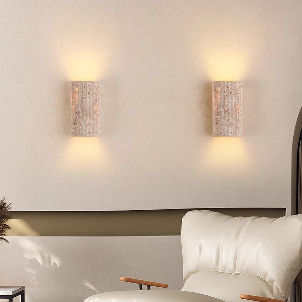 Pair of Talia travertine wall sconces casting up and down light