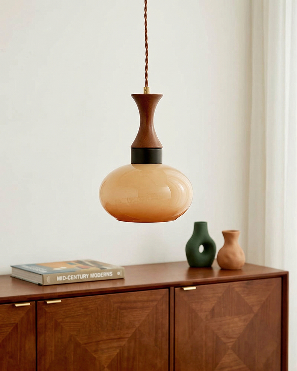Ovia globe pendant light above a walnut sideboard
