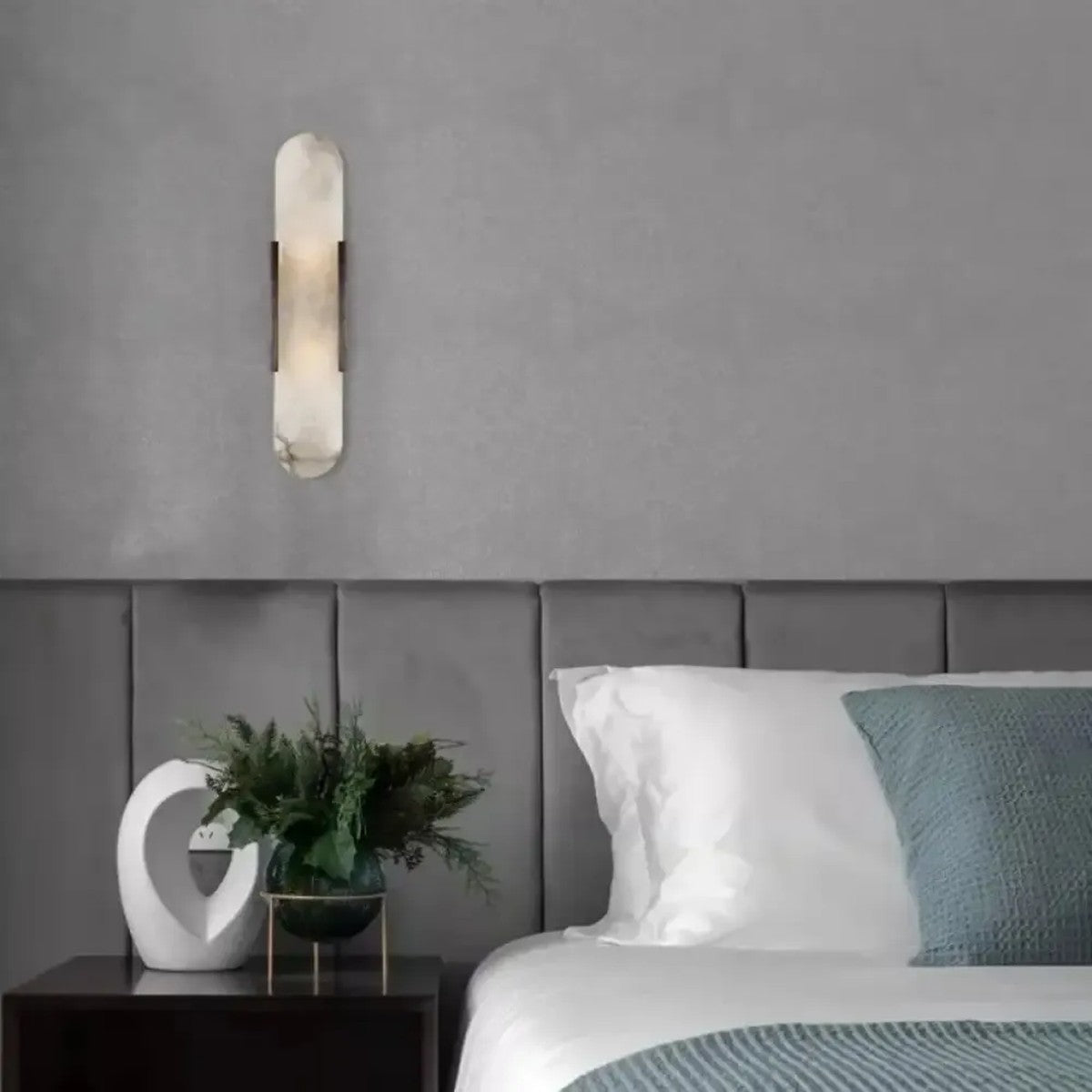 Pietra black stone wall sconce beside a bed