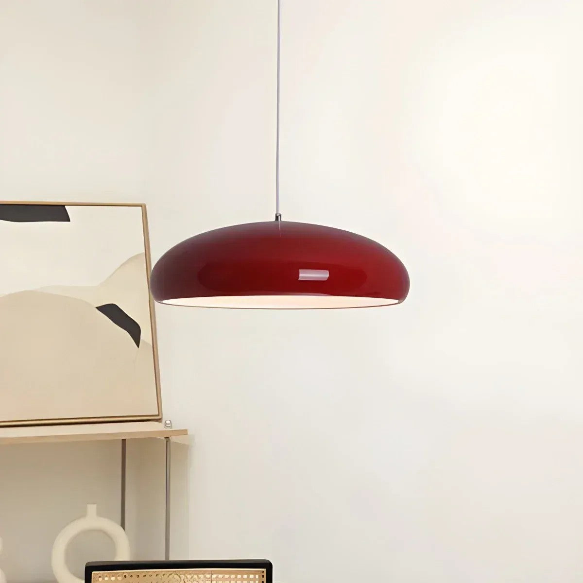 Wine red Lola dome pendant light in front of wall art