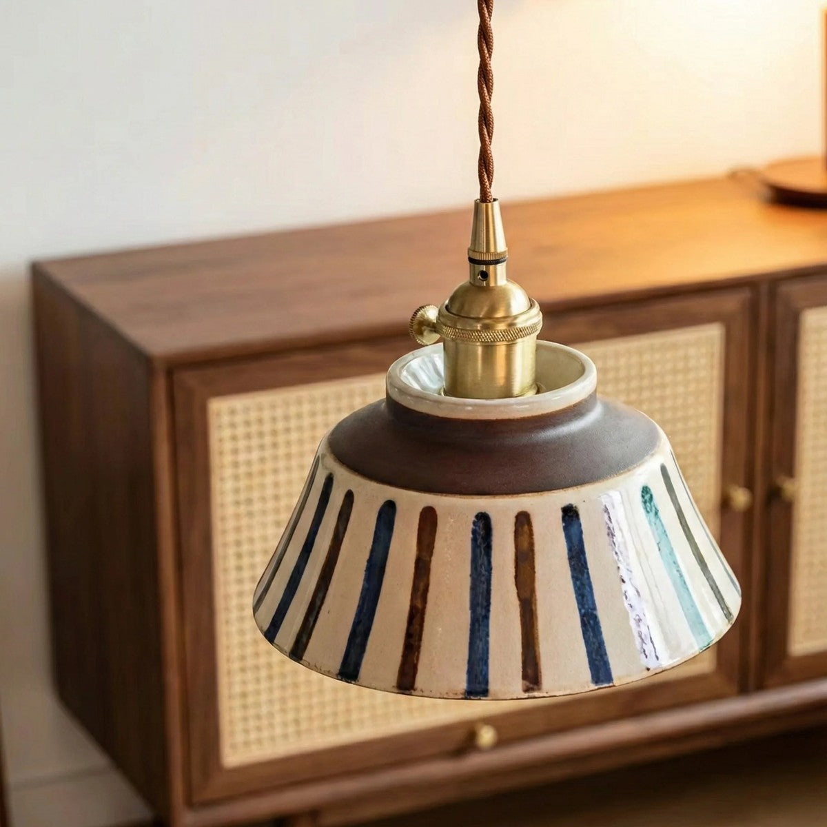 Hana striped ceramic pendant light with brass lampholder above a sideboard