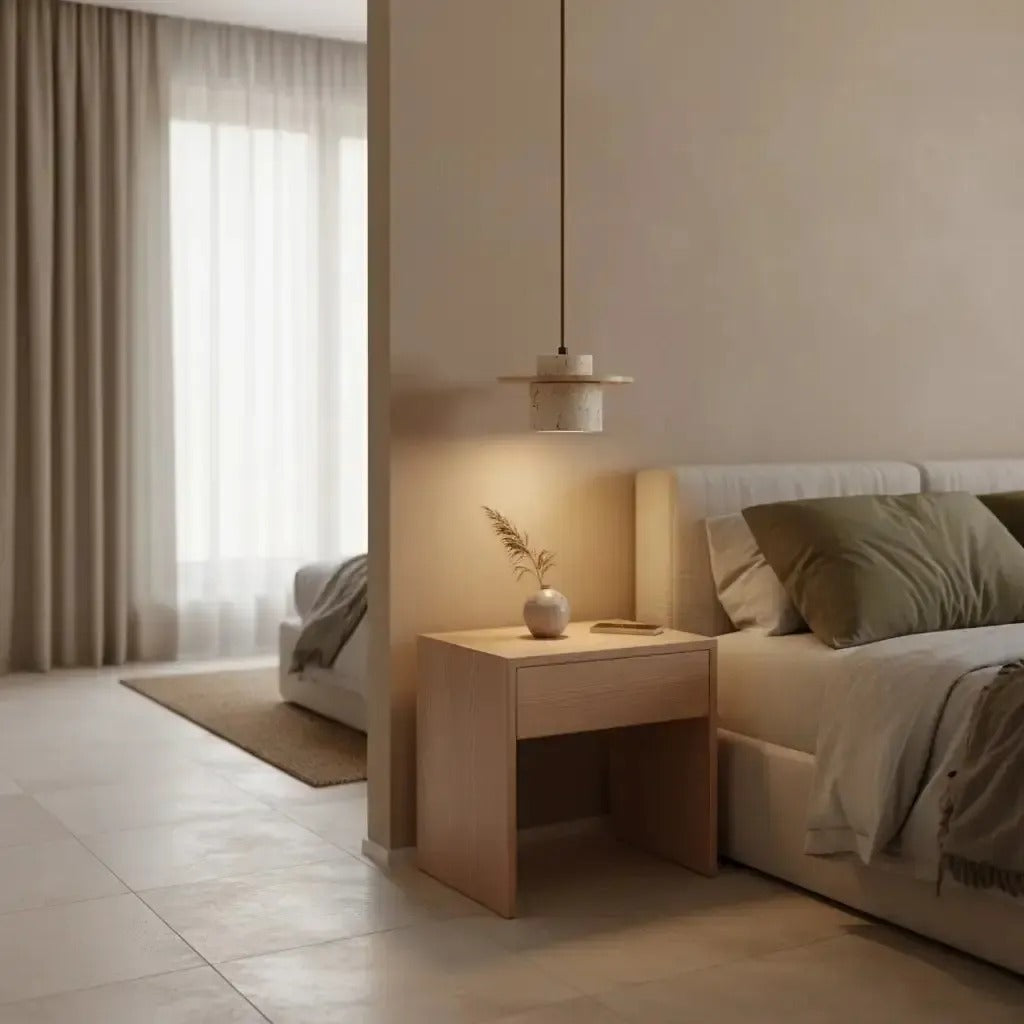 Avra travertine pendant light hanging over a wood nightstand in a bedroom