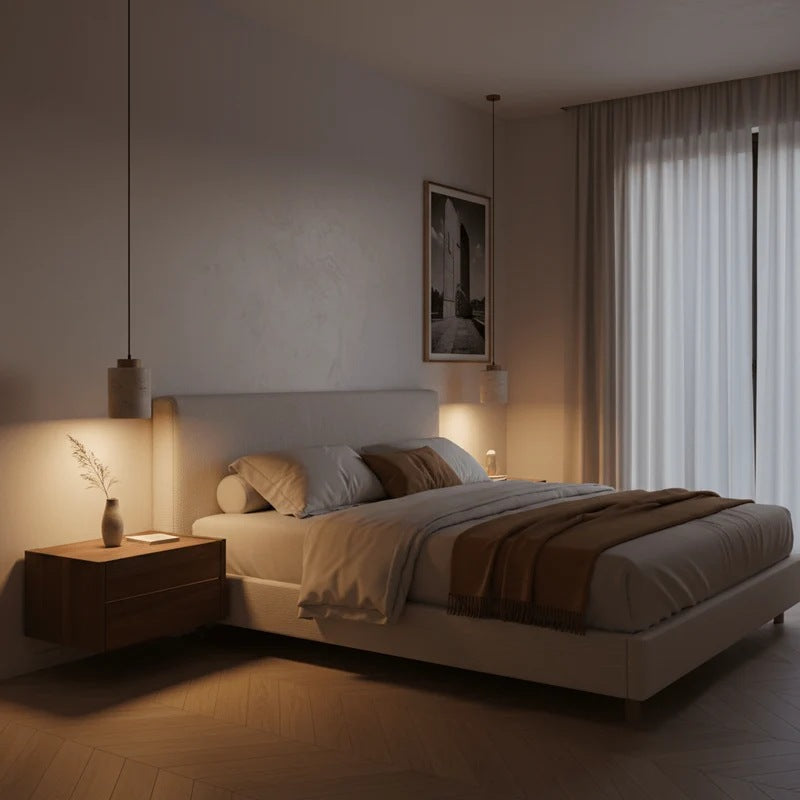 Cora travertine cylinder pendant lights hanging beside a bed