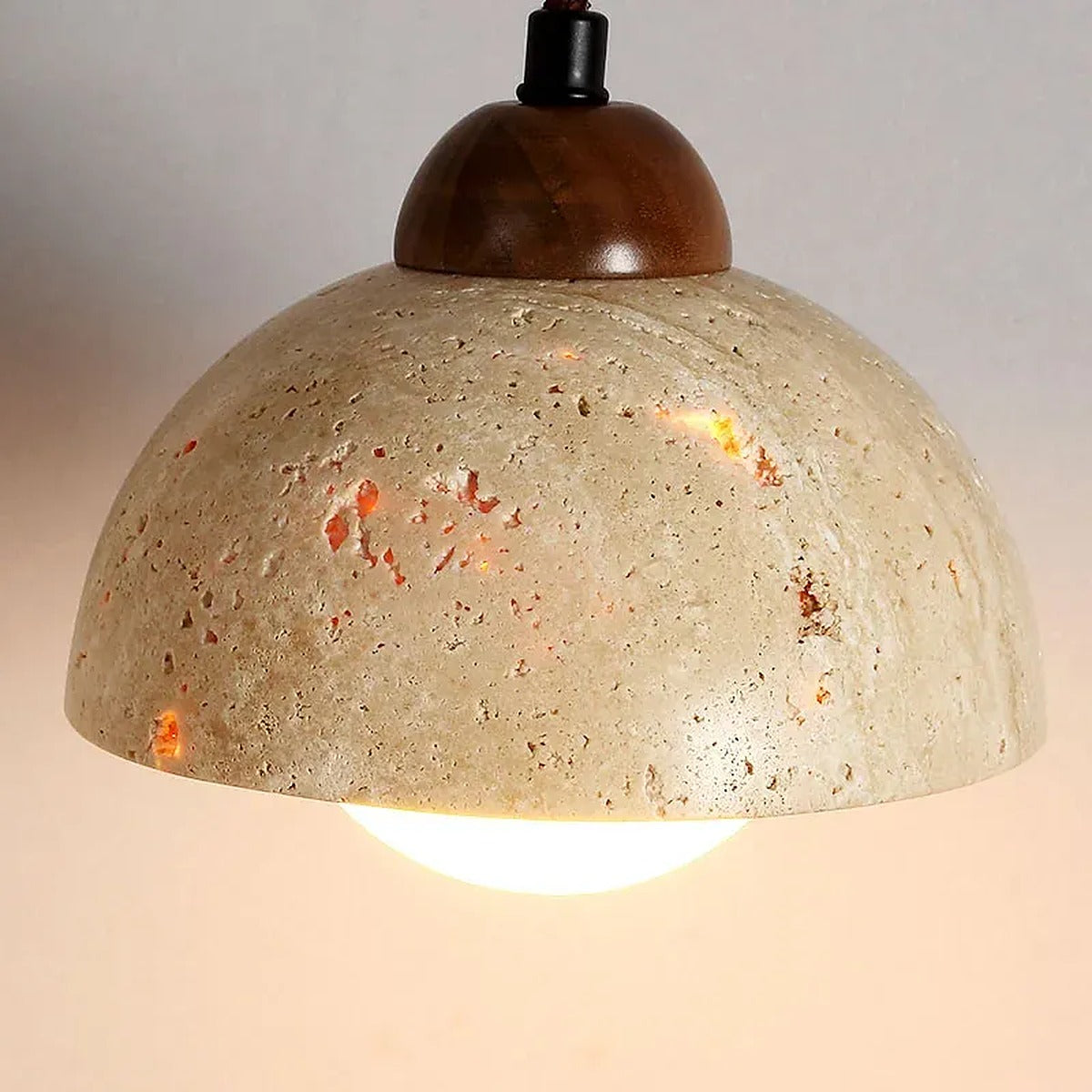 Close-up of the Cora travertine dome shade, walnut cap and opal glass globe
