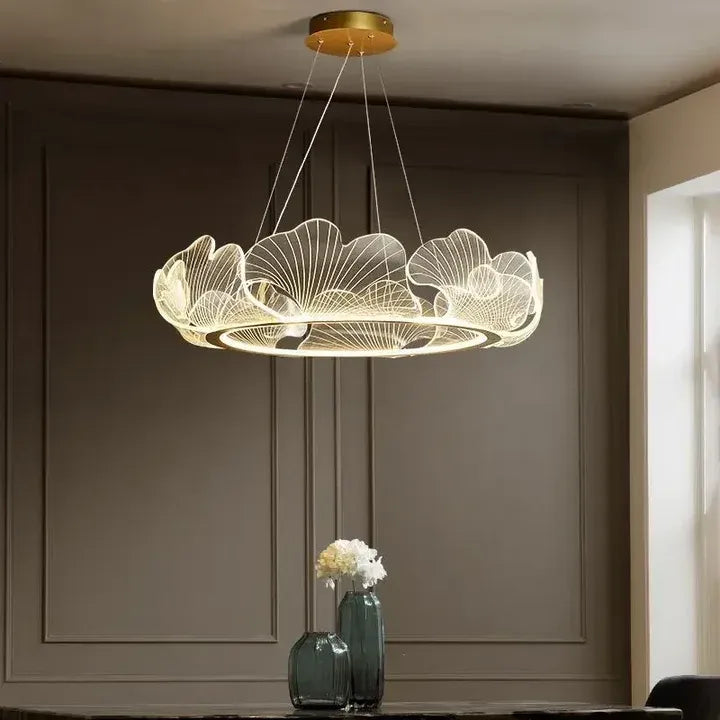 Elara gold ginkgo leaf chandelier glowing in a room with decorative wall panels