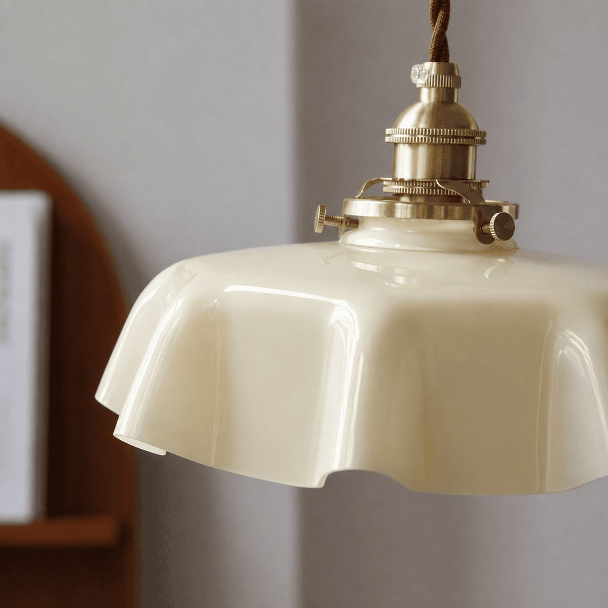 Close-up of the Fleur cream scalloped glass rim and brass socket