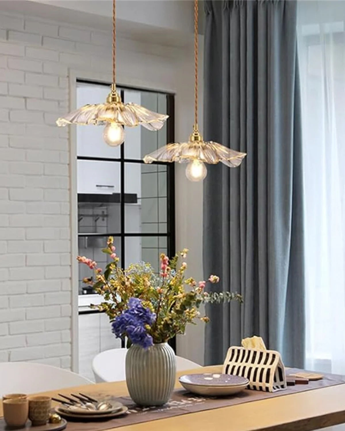 Two Flora clear flower glass pendants over a dining table