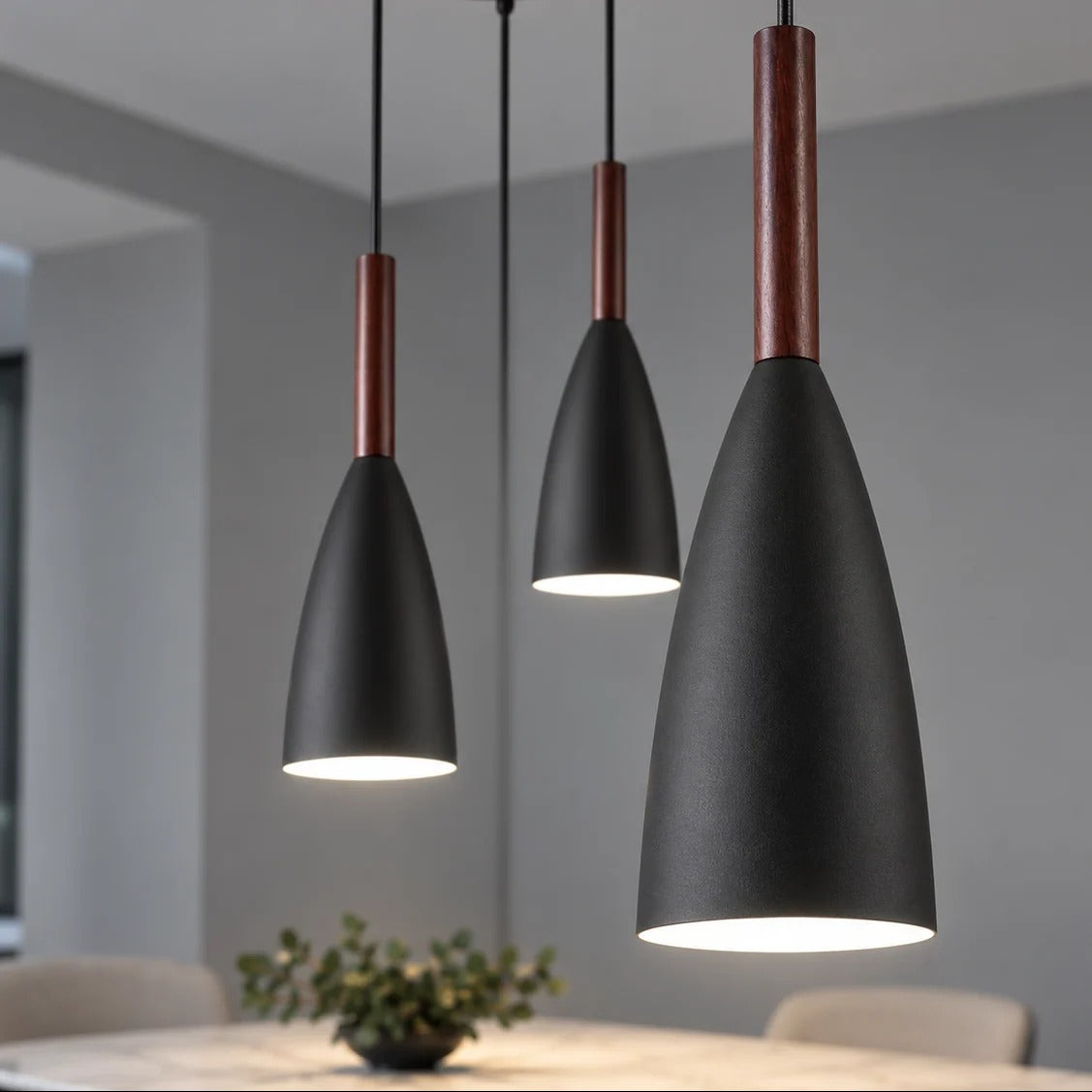Frigga matte black Danish drop pendants with walnut wood necks over a dining table