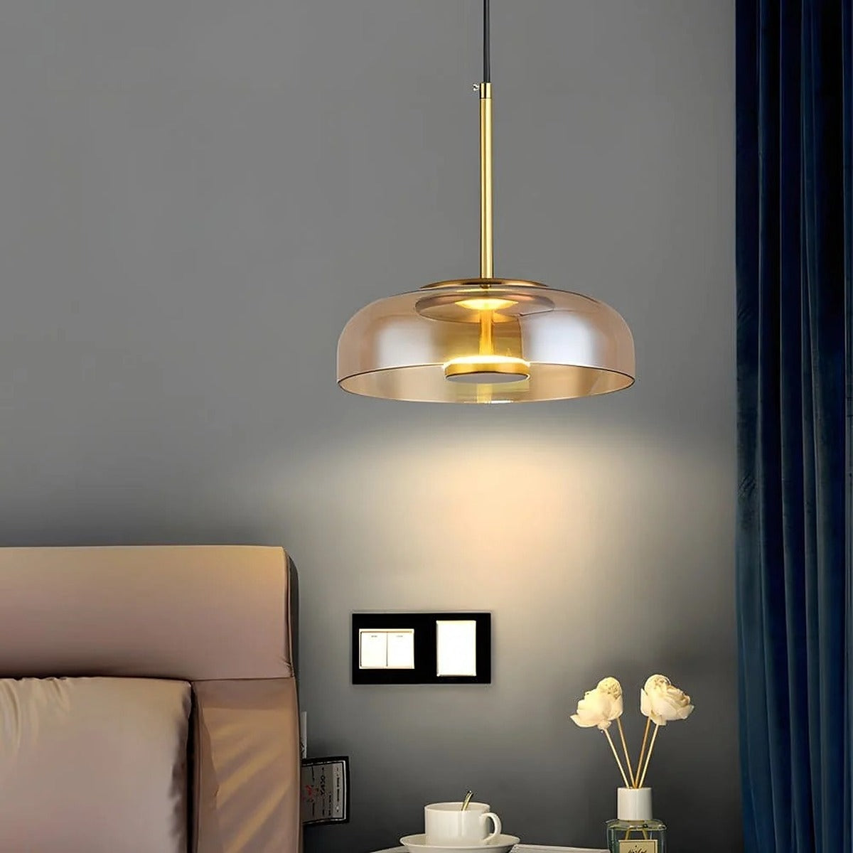 Ivy amber glass LED pendant light beside a bed