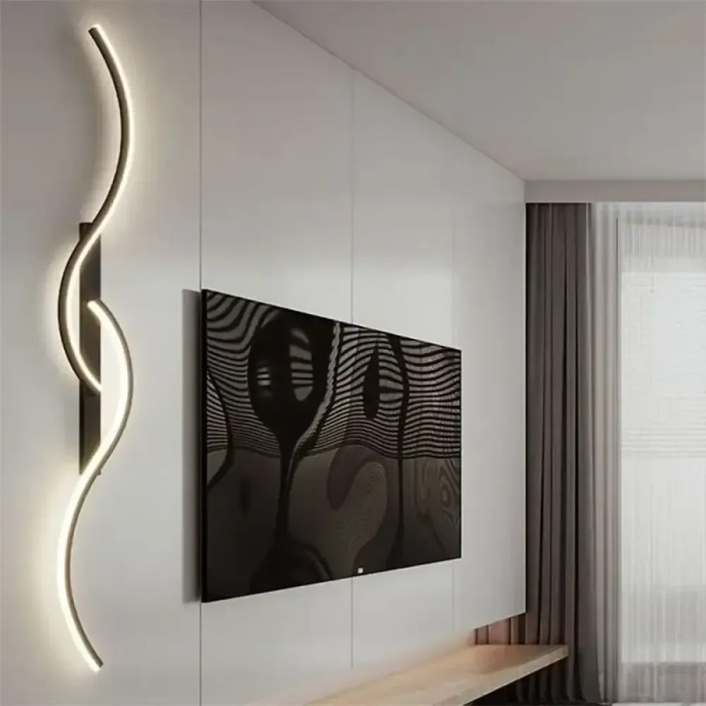 Lyra black wave LED wall sconce beside a wall-mounted TV