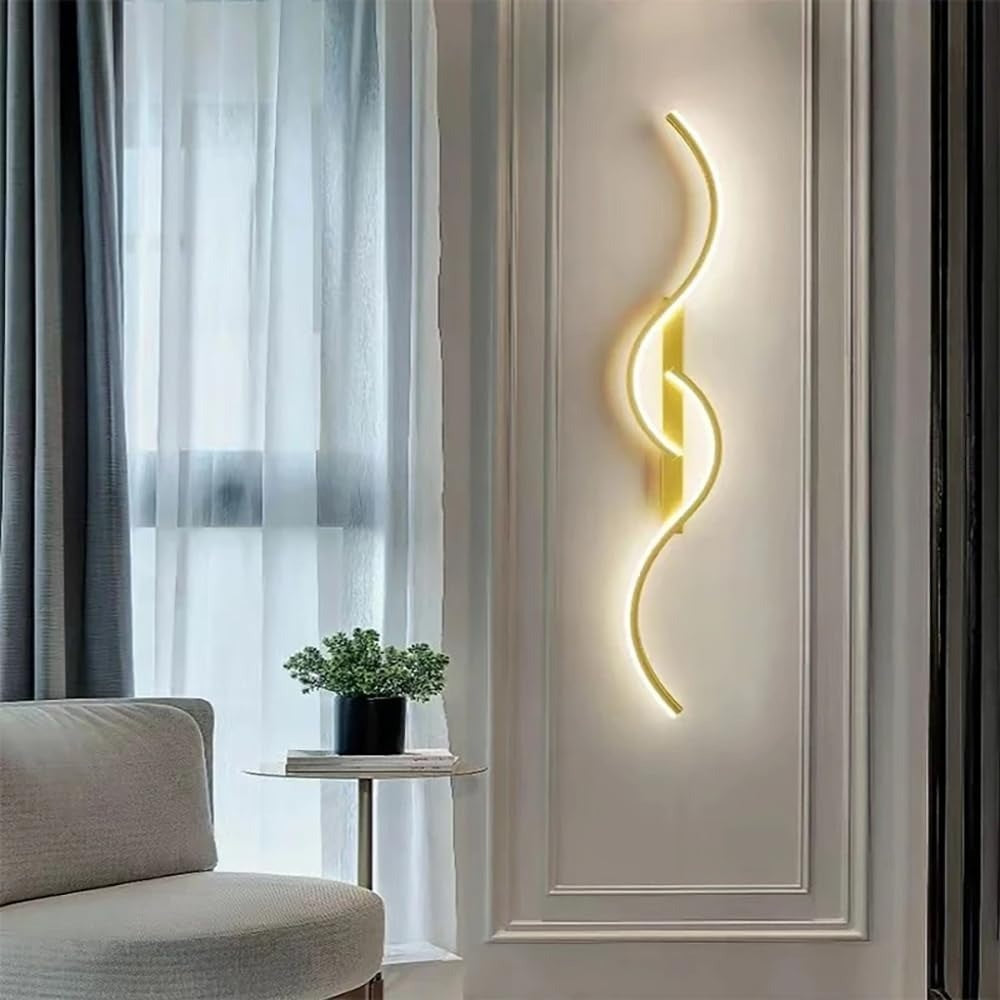 Lyra wave LED wall sconce in gold on a paneled wall beside a window