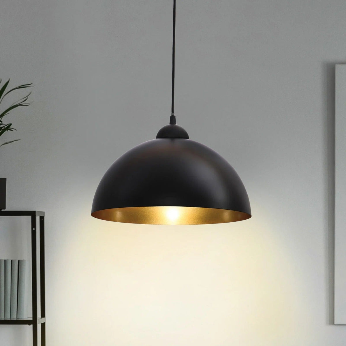 Close-up of the Marlow black metal dome pendant, lit, showing its gold-toned interior