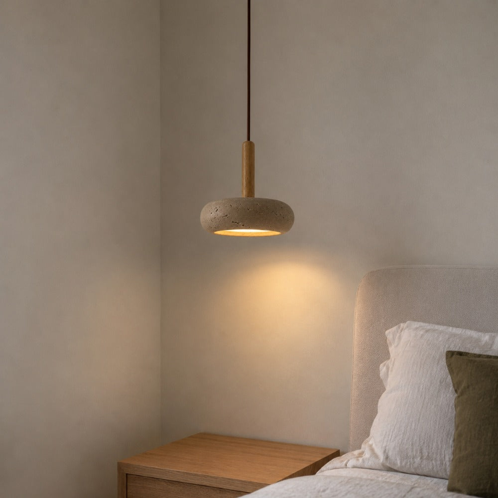 Mila travertine pebble pendant light hanging in a bedroom corner as a bedside light