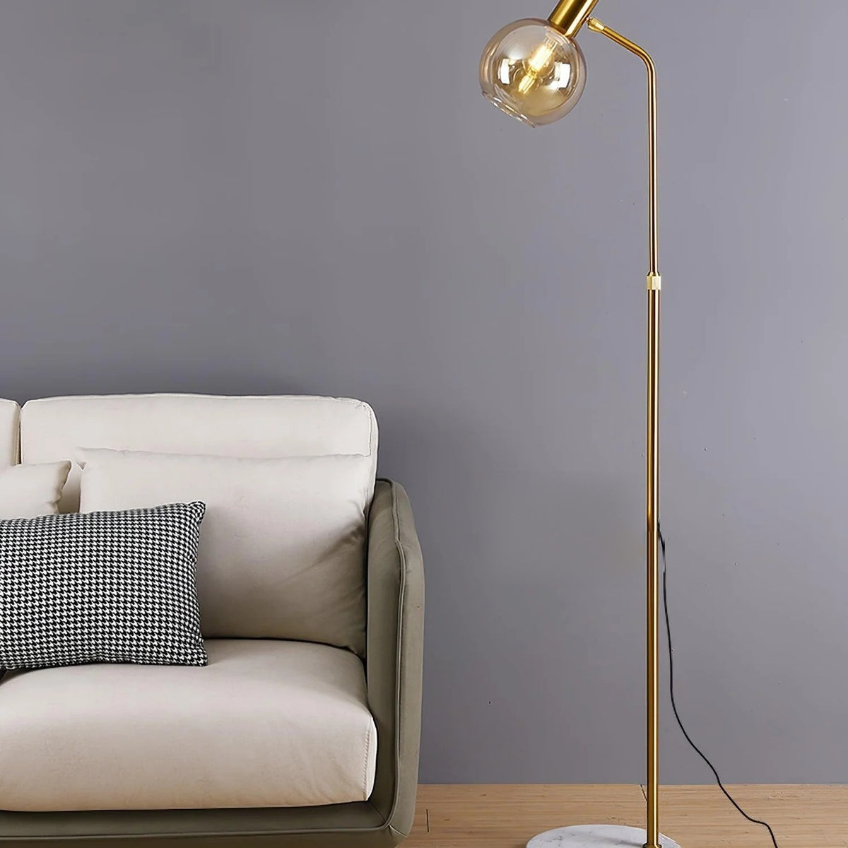Opaline floor lamp in gold with an amber blown glass globe and marble base in a living room