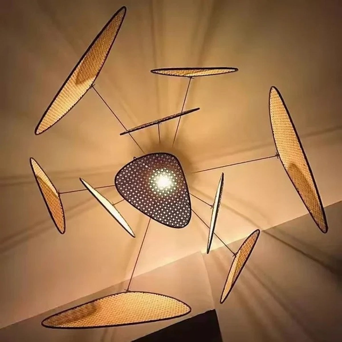 Palma pendant light switched on, casting woven shadows across the ceiling