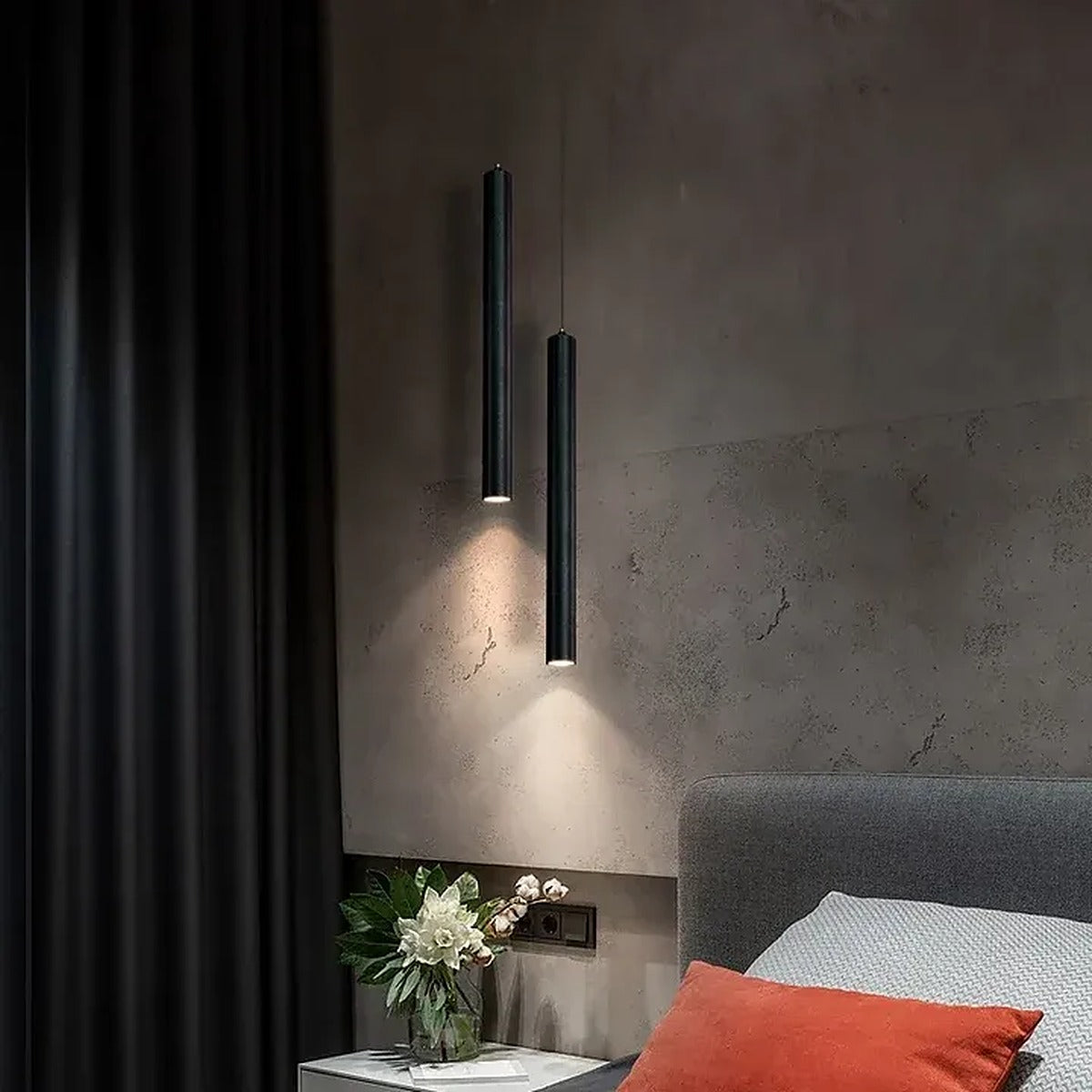 Pike black LED tube pendants lighting a nightstand in a modern bedroom