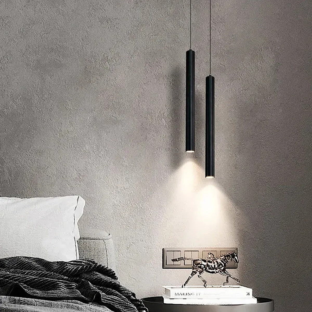 Pike double head black LED tube pendant beside a bed against a concrete wall
