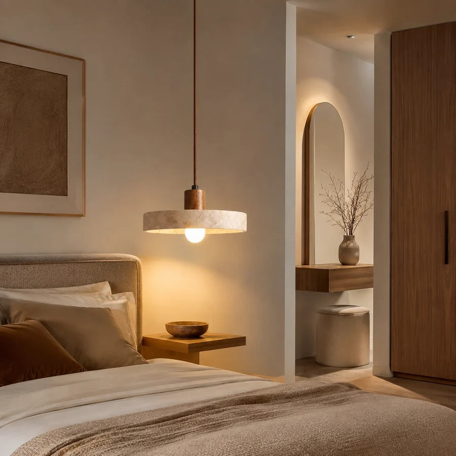 Runa travertine disc pendant light glowing warm over a nightstand