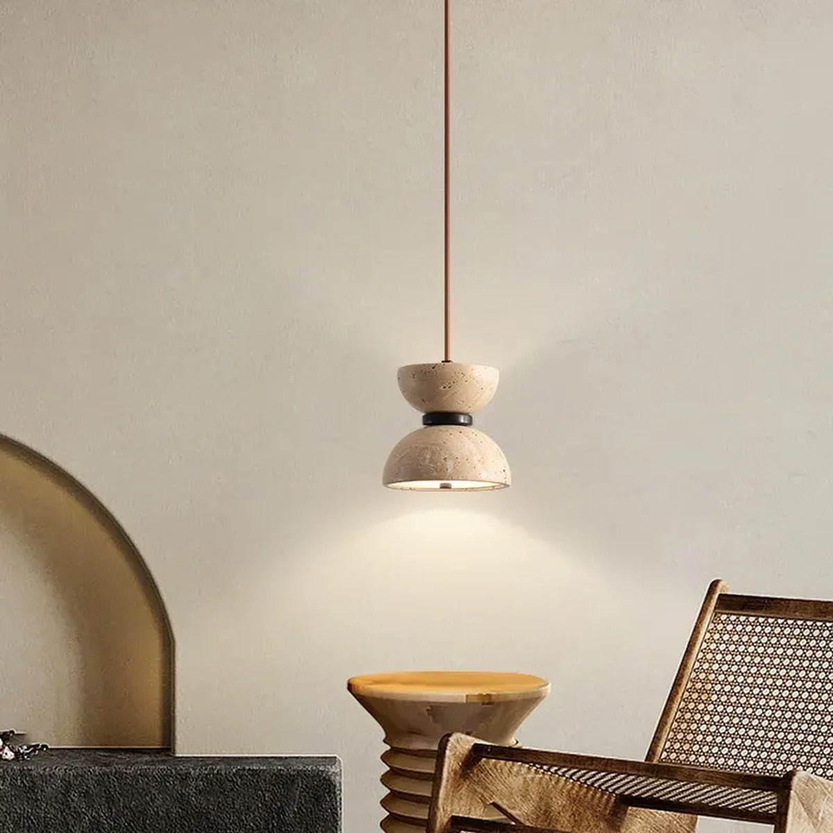 Sable travertine pendant light in a living room corner with a cane lounge chair
