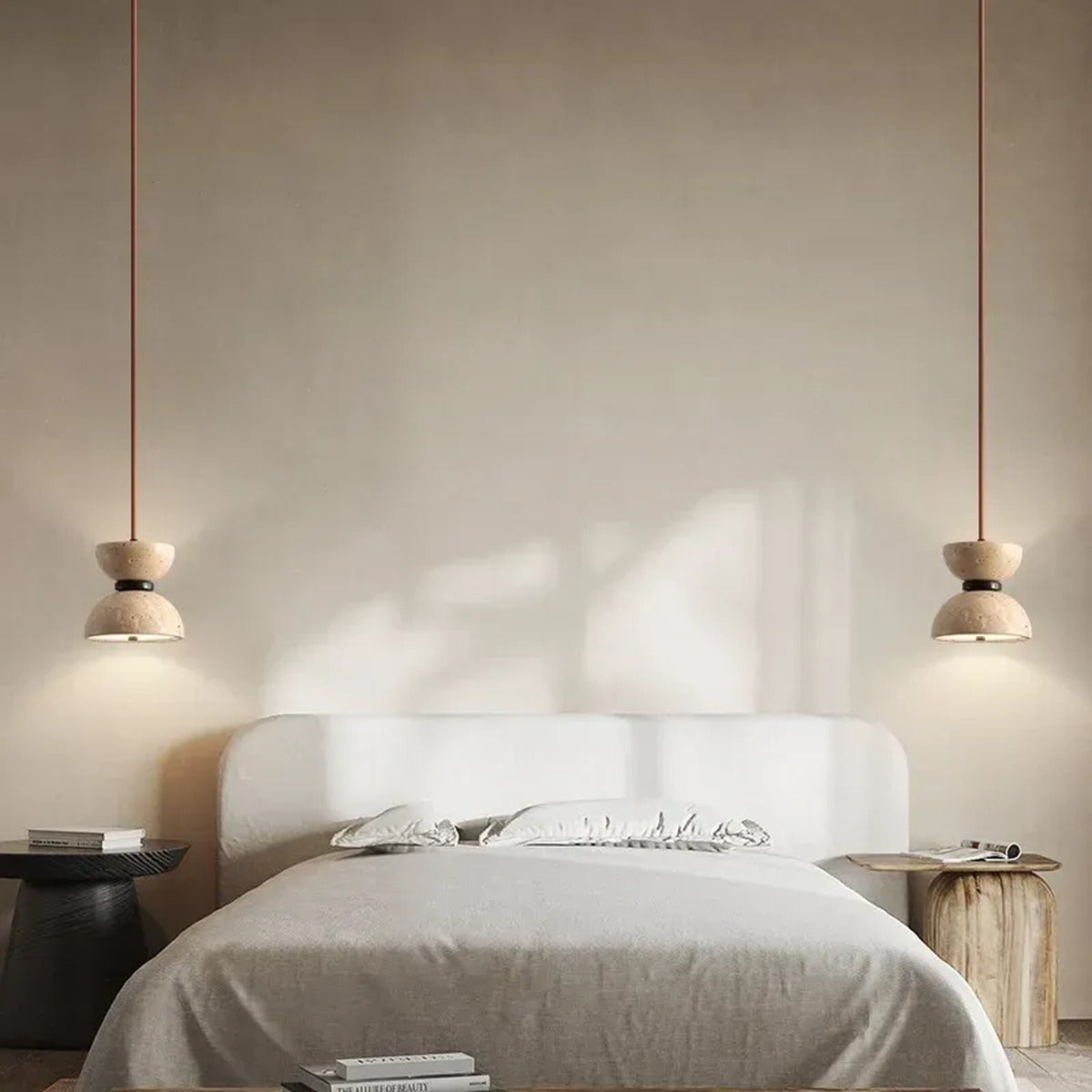 Pair of Sable travertine pendant lights hanging on each side of a bed