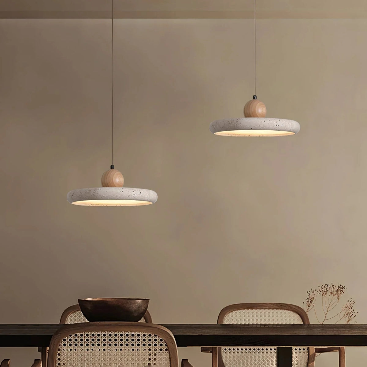Pair of Terra travertine disc pendant lights over a dining table