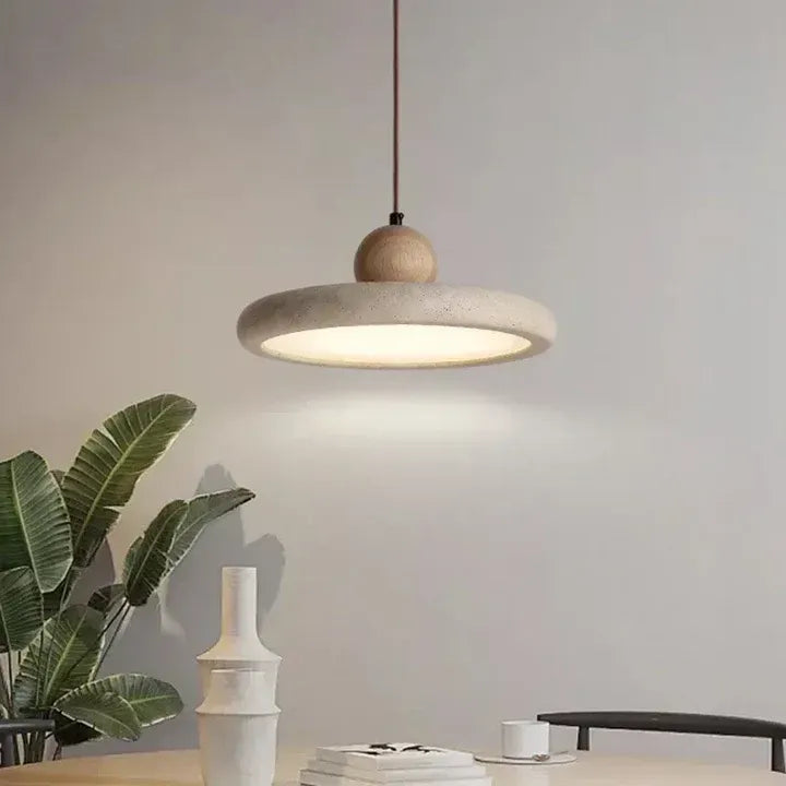Lit travertine disc pendant light in a neutral interior