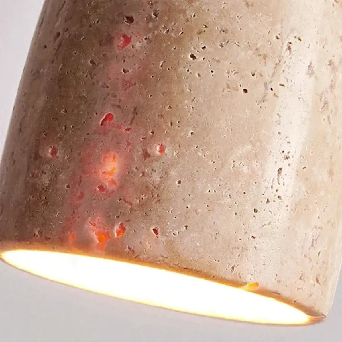 Close-up of the natural travertine texture and pores on the Tova pendant shade