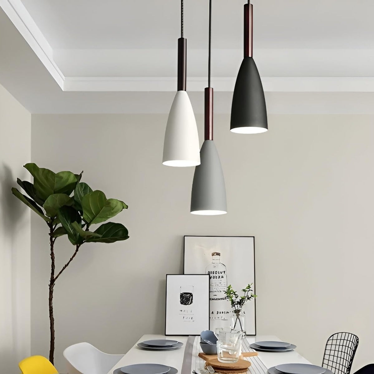 Three single Vika slim pendant lights in white, gray and black hung over a dining table