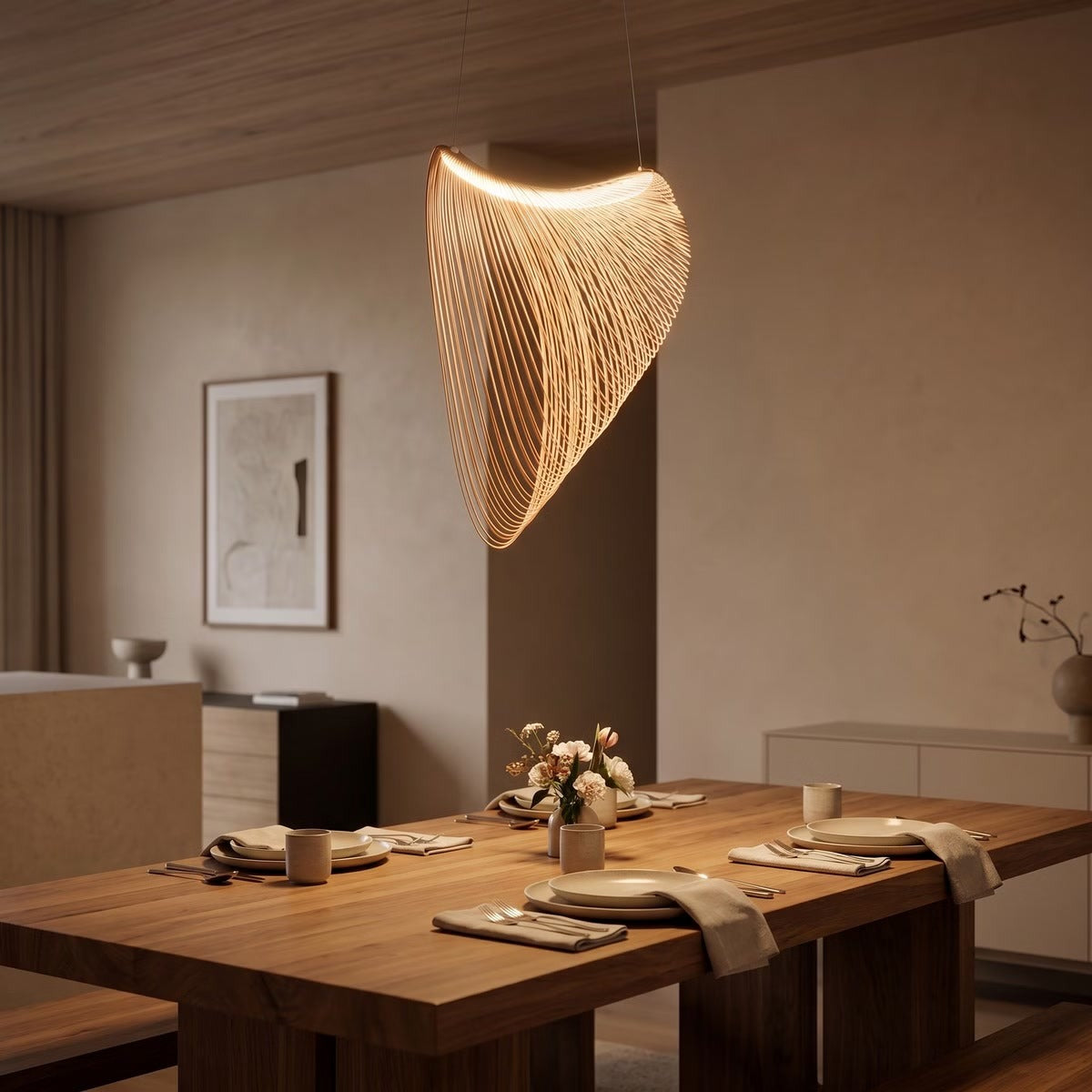 Wren wood-tone LED pendant glowing above a solid wood dining table