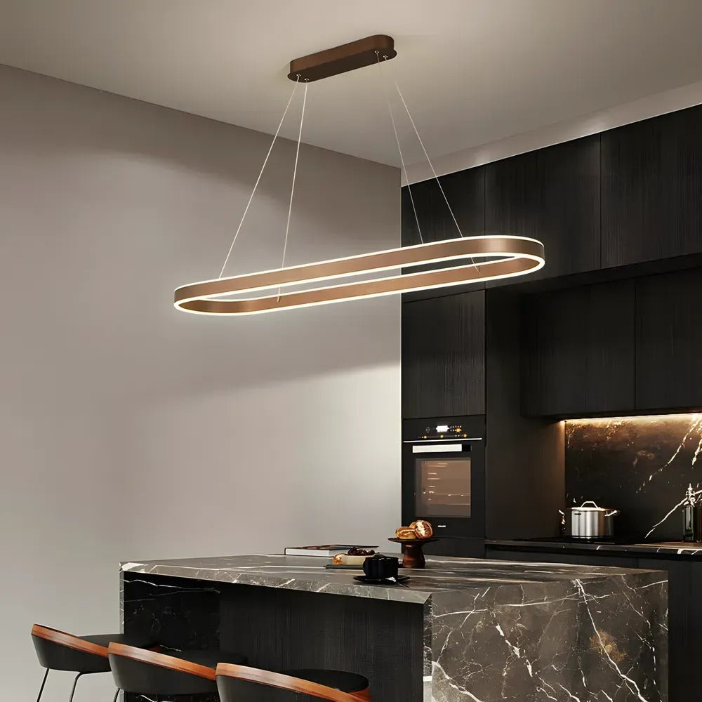 Halo oval LED pendant light in coffee brown above a dark marble kitchen island