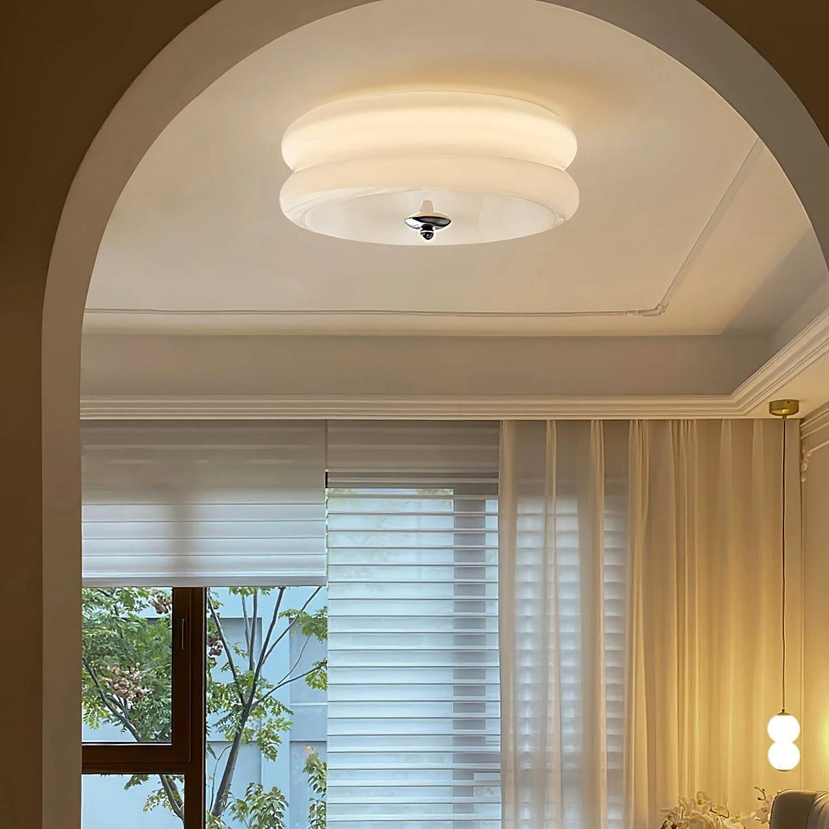 Margot flush mount ceiling light in white glass above an arched living room doorway