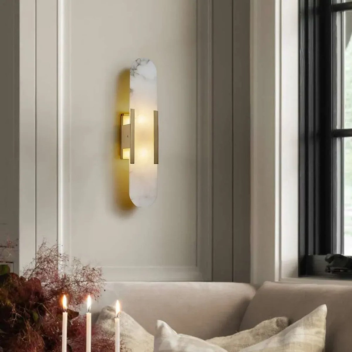 Pietra gold stone wall sconce above a living room sofa