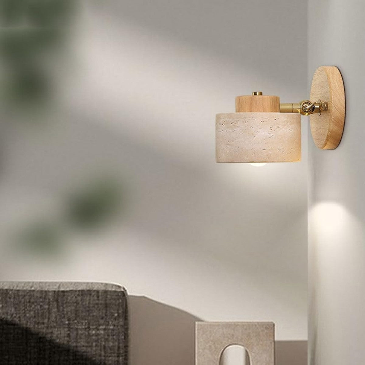 Cairn light wood travertine wall sconce lit in a living room