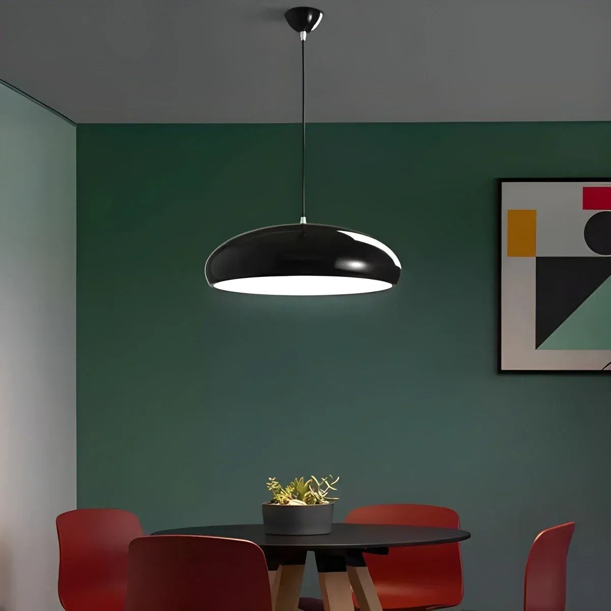 Black Lola dome pendant light in a dining room with a green wall