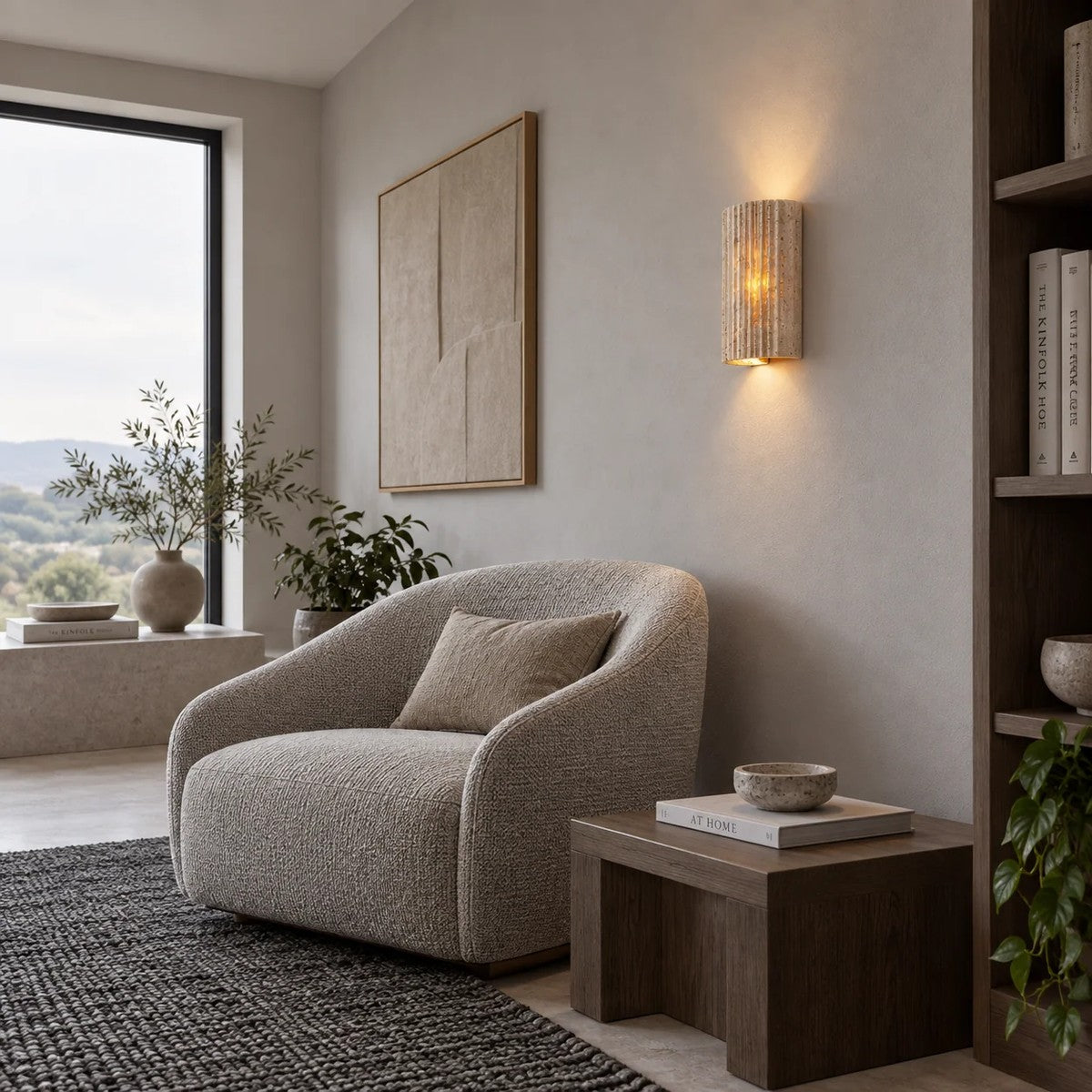Talia fluted travertine wall sconce above an armchair in a living room
