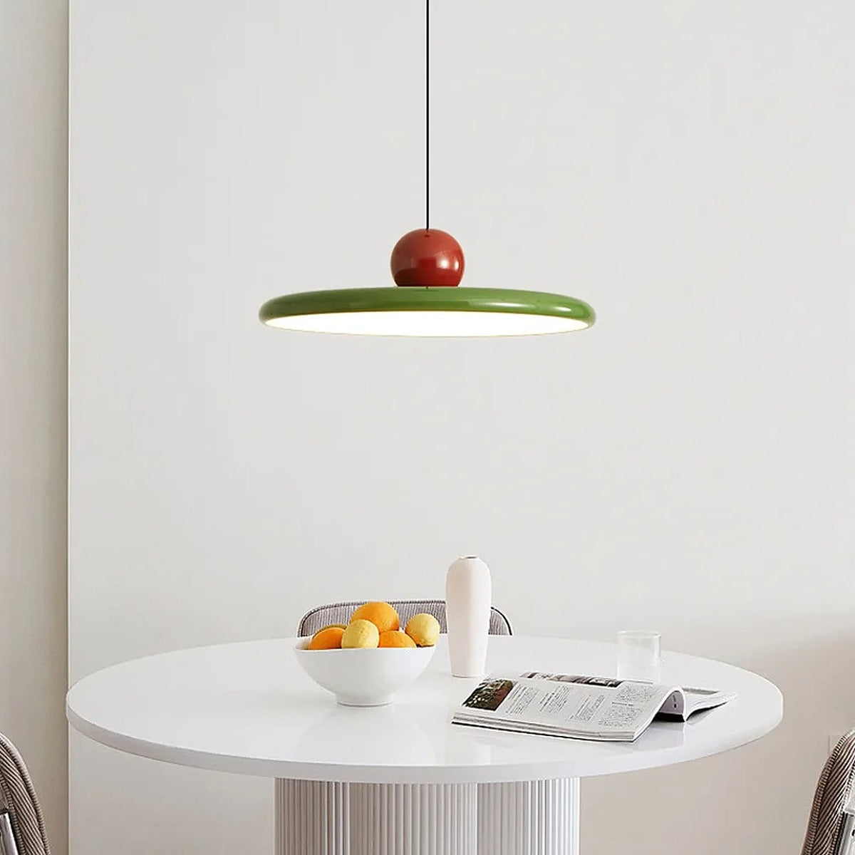 Green and red Juno saucer pendant light over a round table