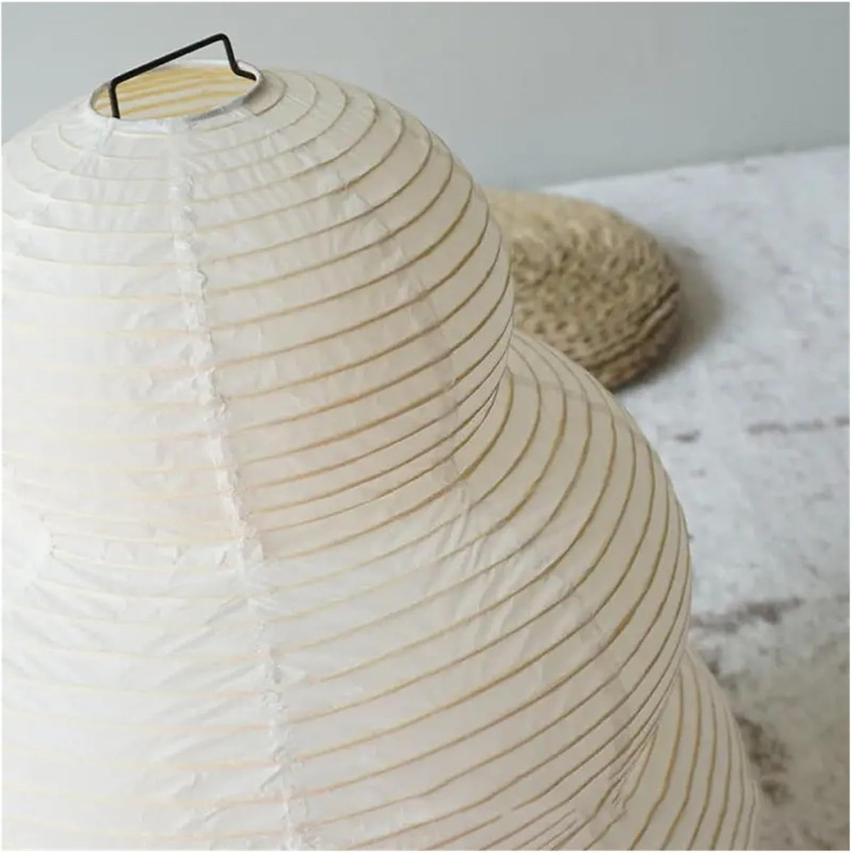 Close-up of the Kumo rice paper shade with fine horizontal ribbing and wire handle