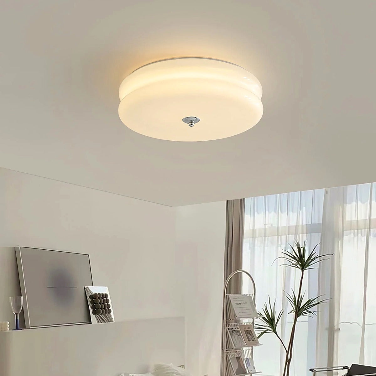 Margot white glass flush mount ceiling light lit in a bright bedroom