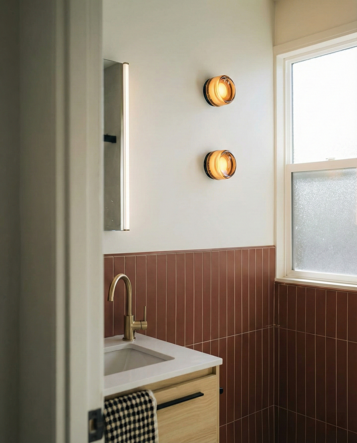 Pair of amber Orla wall lights beside a bathroom mirror