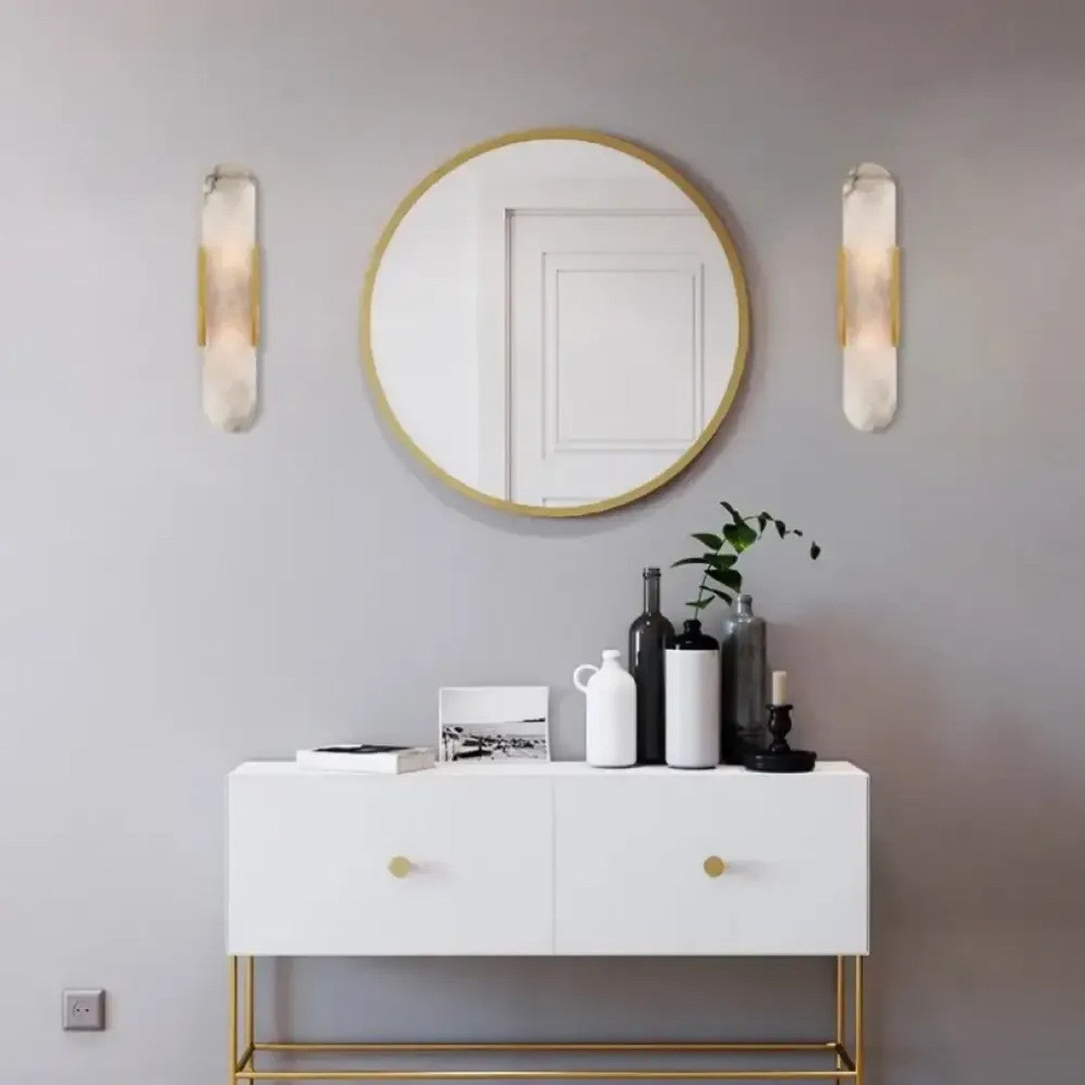 Pietra gold wall sconces either side of an entry mirror