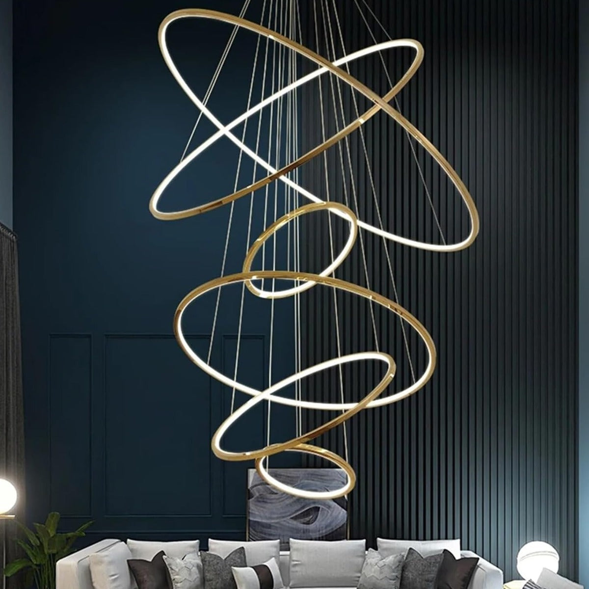 Gold Vela 6-ring LED chandelier in a living room with a navy wall
