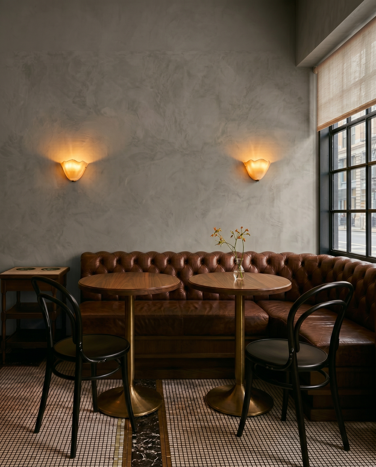 Pair of ivory Calla wall lights in a cafe with a leather banquette