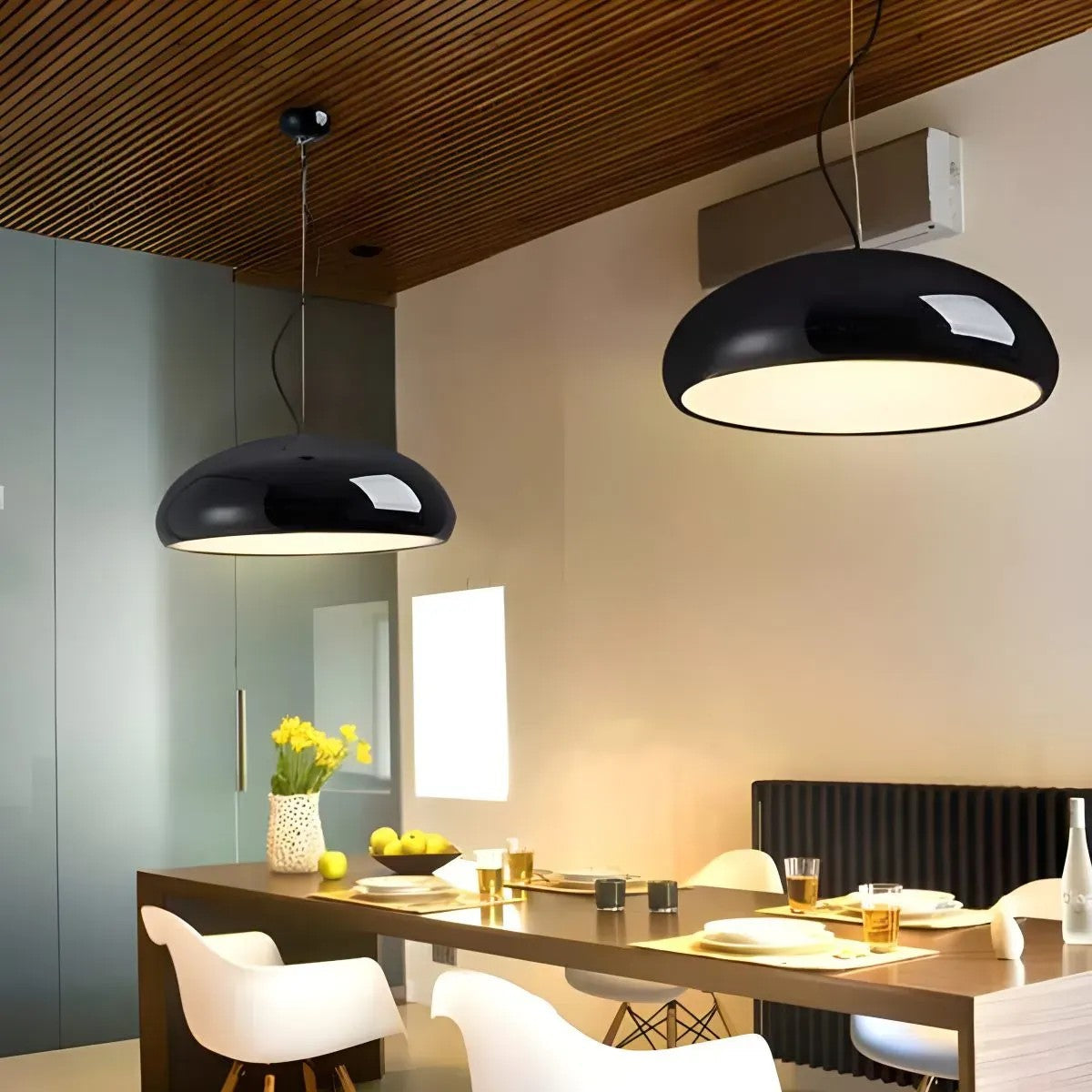 Two black Lola dome pendant lights above a long dining table