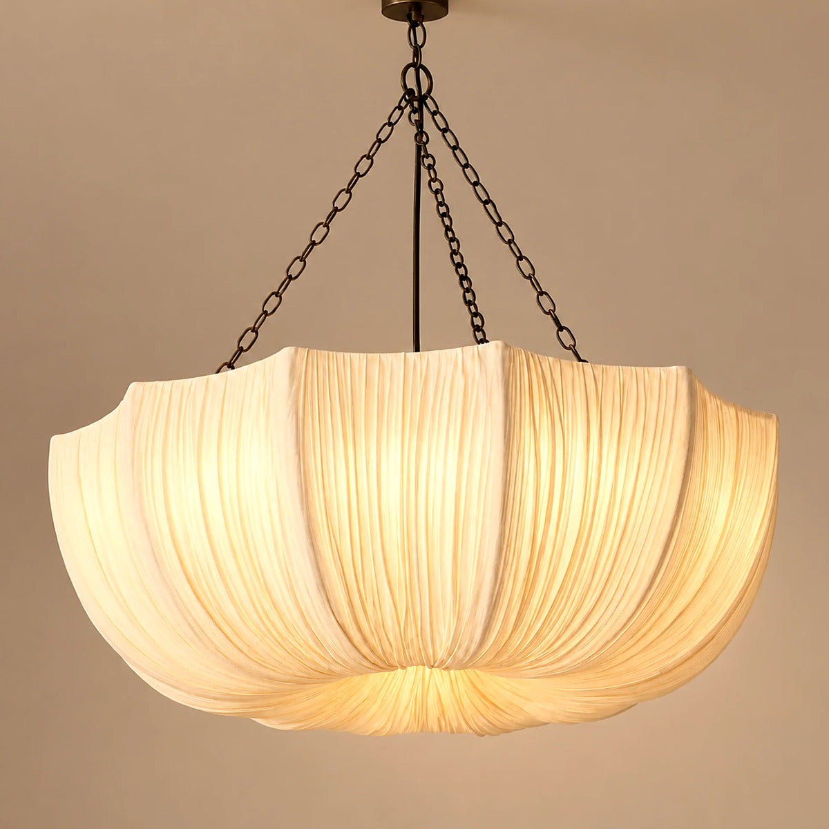 Maris pleated fabric chandelier lit, hanging from dark chains