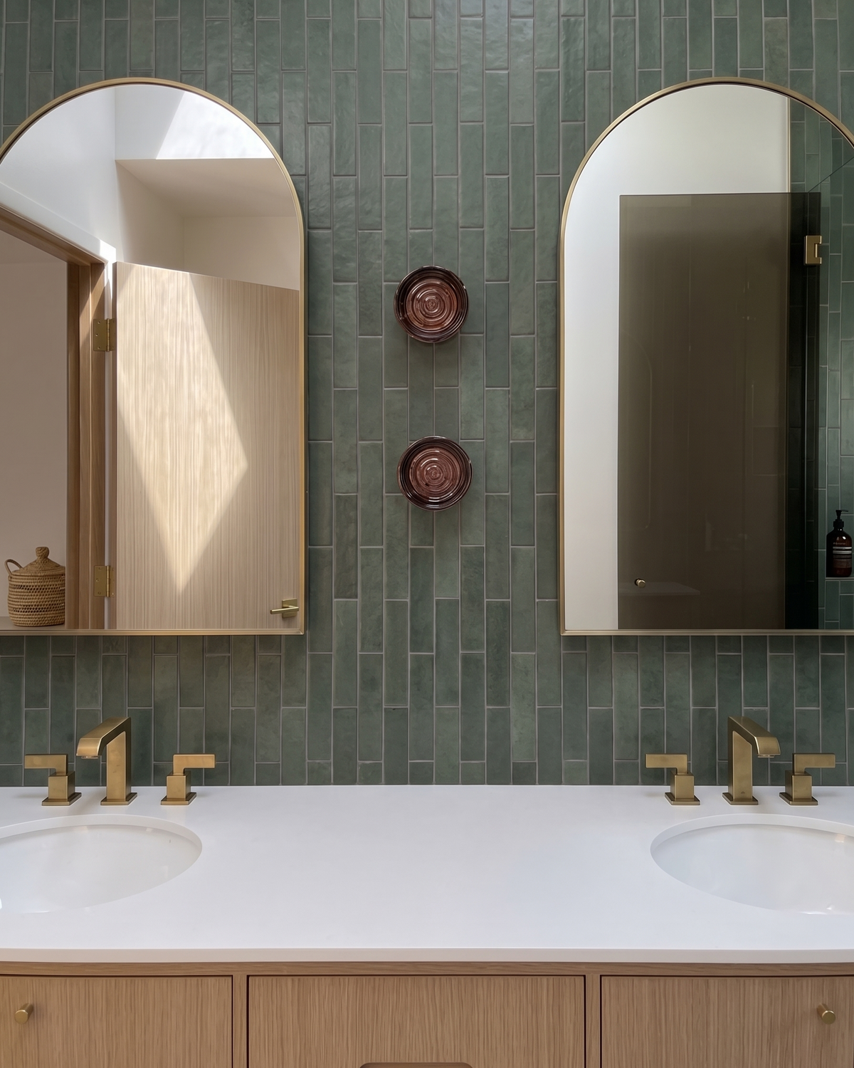Orla wall lights between two arched mirrors above a double vanity