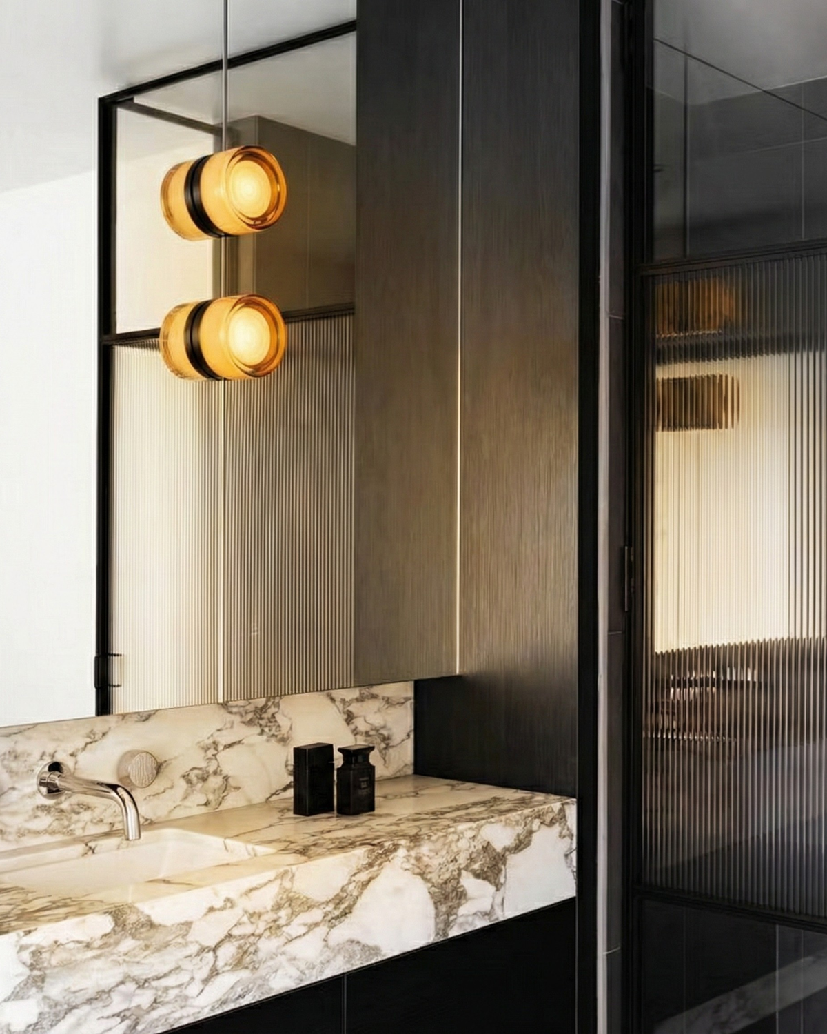 Amber ripple Orla wall lights in a marble bathroom